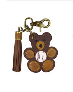 a brown bear key chain with a baseball on it's back and a tassel