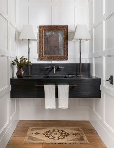 a bathroom sink with two towels hanging on the wall