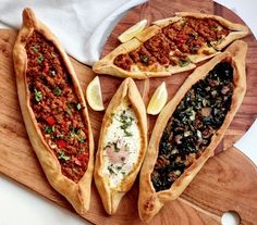 three different types of bread on a cutting board next to some other foods and toppings