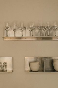 several wine glasses and bowls are on the shelf