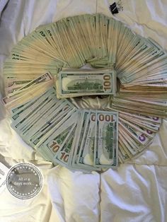 a pile of money sitting on top of a bed