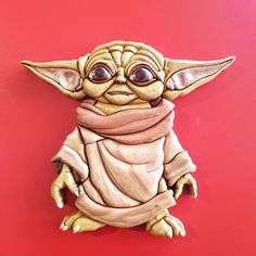 a star wars yoda figurine on a red background