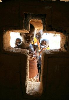 a group of young children standing inside of a brick building