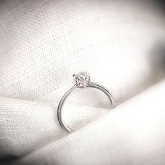 a diamond ring sitting on top of a white cloth