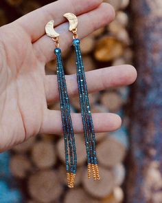 a person is holding up some beads in their hand and the earrings are made out of gold - plated metal