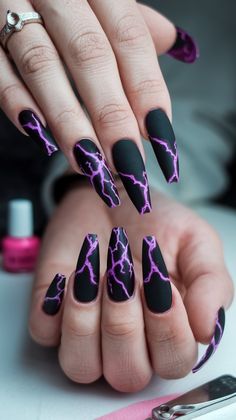 Get ready to shock with these edgy stiletto nails! Featuring a sleek black base paired with a mesmerizing purple lightning pattern, these nails bring an electrifying vibe to any outfit. Perfect for concerts, parties, or just because you want to shine! #acrylicnails #nailsdesign #nailsinspo #octobernails Nails With Lightning, Black Nails With Lightning, Edgy Stiletto Nails, Nails For Rock Concert, Lightening Nail Designs, Nails Black And Purple, Storm Nails Design, Purple Lightning Nails, Lightning Nail Art