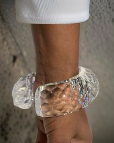 This Croc lucite cuff bracelet showcases a rounded and continuous design, entirely hand-sculpted for a unique and high-quality piece. Made with exquisite craftsmanship, it adds a touch of elegance and sophistication to any outfit. Expertly crafted and designed for durability, this bracelet is a must-have for any fashion enthusiast. Round Lucite Jewelry For Parties, Handmade Elegant Clear Bracelets, Elegant Handmade Clear Bracelets, Elegant Adjustable Carved Bangle, Clear Lucite Party Jewelry, Modern Clear Bracelet Jewelry, Elegant Carved Cuff Bracelet, Elegant Adjustable Carved Bracelet, Elegant Carved Adjustable Bracelet