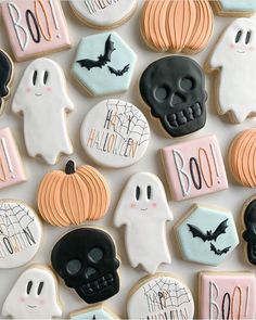 halloween cookies decorated with black, white and pink icing are arranged in a pattern