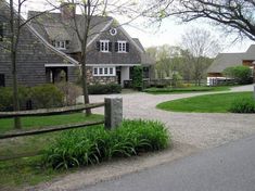 a large house with a driveway in front of it and lots of greenery on the side