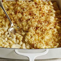 macaroni and cheese in a white casserole dish with a spoon