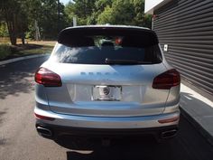 the back end of a white car parked on a street