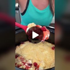 a woman is spooning cranberry sauce out of a skillet with a red spatula