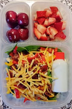 a plastic container filled with salad and fruit