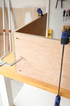 a workbench with tools on it and some wood planks in the background