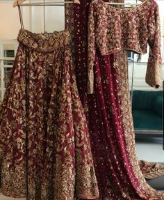 two dresses hanging on a rack in a room