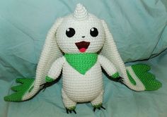 a crocheted stuffed animal with a green bandanna around it's neck