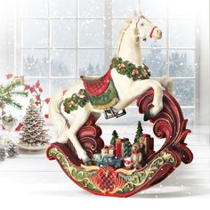 a christmas rocking horse with presents on the sleigh in front of a window