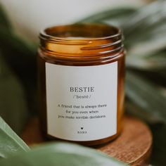 a jar of honey sitting on top of a wooden table next to a green plant