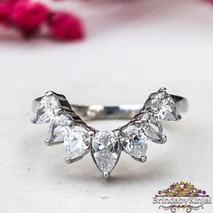 a white gold ring with three pear shaped diamonds