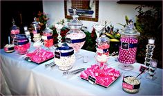 a table topped with lots of candy and candies on top of it's trays