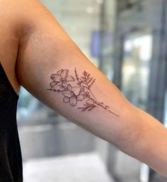 a woman's arm with a flower tattoo on the left side of her arm