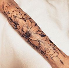 a person with a tattoo on their arm has a flower and leaves design on it