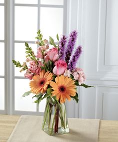 a vase filled with lots of flowers on top of a table