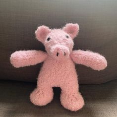 a pink stuffed animal sitting on top of a couch