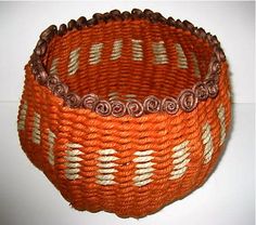 an orange basket with white and brown designs on it