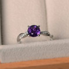 This ring features a 7*7 mm round cut natural amethyst ,and sterling silver finished with rhodium. Customization is available. It is made by hand, and it will take about 7 days to finish the ring after your payment is completed. Main stone: natural amethyst Main stone weight: Approx 1.25 ct Metal type: sterling silver finished with rhodium Accent stone: cz Customization is available, I also can make it with 14k solid gold (white or yellow or rose) and diamond accent stone, just feel free to cont Punk Rock Jewelry, Amethyst Rings, Original Engagement Rings, Green Amethyst Ring, London Blue Topaz Ring, Twisted Band, Purple Band, Titanium Rings, February Birthstone