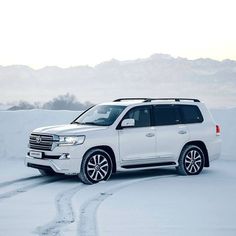 a white suv is parked in the snow