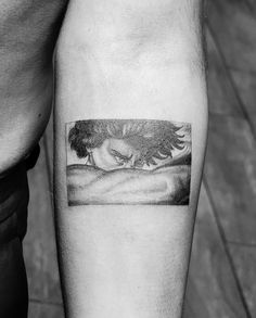 a black and white photo of a woman's arm with an eagle tattoo on it