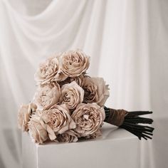 a bouquet of flowers sitting on top of a white box