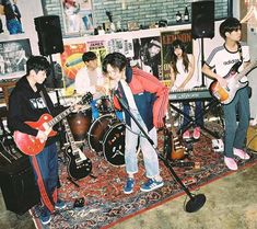 a group of young men playing guitars in a room