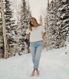 a woman standing in the snow with her hands on her hips