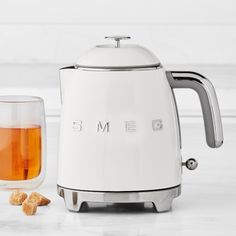 a white toaster sitting on top of a counter next to a glass filled with liquid