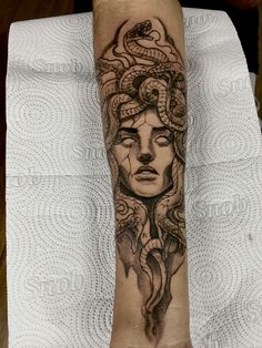 a woman's foot with a tattoo on it and a snake crawling around her head