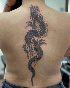 a woman with a dragon tattoo on her back