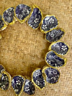 a close up of a wreath made with blue and white flowers on a woven surface