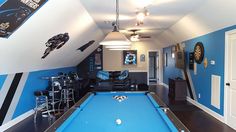 a pool table is in the middle of a room with blue walls and black flooring