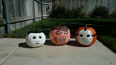 three pumpkins painted to look like halloween characters