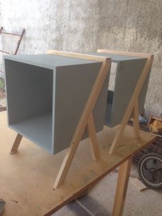 two gray boxes sitting on top of a wooden table