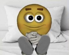 an emoticive smiley face sitting on top of a bed