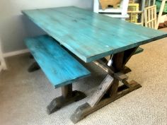 a wooden table with two benches in the middle and one bench at the end on carpeted flooring