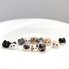 a white plate topped with lots of small black and white kitten figurines next to each other