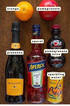 an assortment of different types of alcohol on top of a wooden table next to oranges