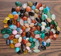 many different colored stones on a wooden surface