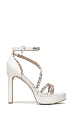 The sandal features dazzling jewels that detail slender satin straps with a subtle platform base and tapered heel. World-renowned bridal designer Pnina Tornai created a dreamy collection with Naturalizer of wedding-ready styles that exude luxurious elegance and are aptly named 'love' in different languages. 3 3/4" heel; 3/4" platform Slip-resistant sole Textile upper and lining/leather sole Imported Embellished Ankle Strap Sandals For Prom, Glamorous Rhinestone Wedding Sandals, Ankle Strap Sandals With Rhinestones For Wedding, Rhinestone Ankle Strap Sandals For Wedding, White Embellished Sandals For Gala, Glamorous Open Heel Sandals For Wedding, Glamorous White Sandals For Prom, Glamorous Open Heel Wedding Sandals, Elegant Embellished Sandals For Prom