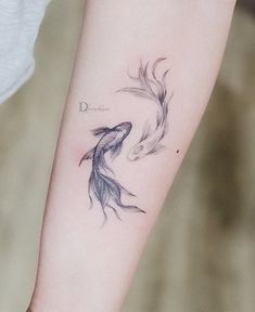 a woman with a tattoo on her arm that has two koi fish in it