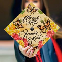 a woman wearing a graduation cap that says always stay humble and kind with butterflies on it